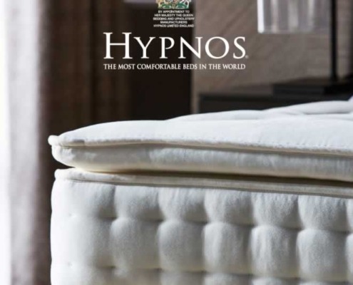 an image of the corner of a bed and and mattress with the Hypnos logo
