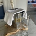 a bottle of prosecco in a silver ice bucket with a wahite linen cloth and two champagne fglutes ready to serve